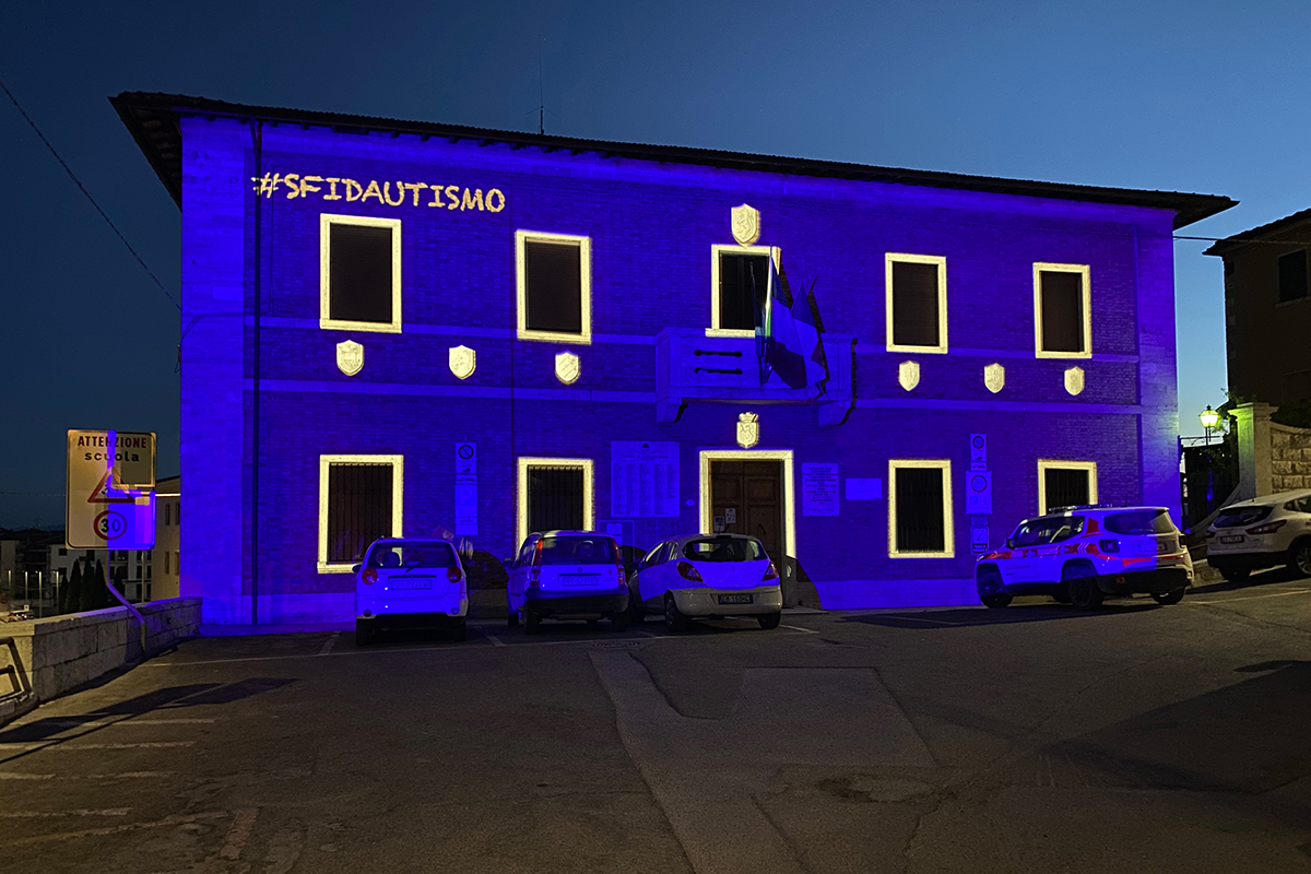 Palazzo comunale di rapolano illuminato di blu, con contorni finestre bianchi e logo #sfidautismo in occasione della Giornata Mondiale dell'Autismo